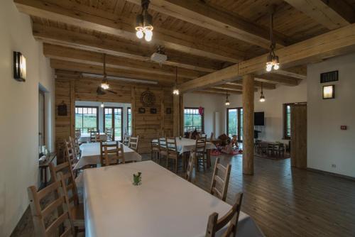 a dining room with tables and chairs and wooden ceilings at Kompleks Małe Dolomity in Hucisko