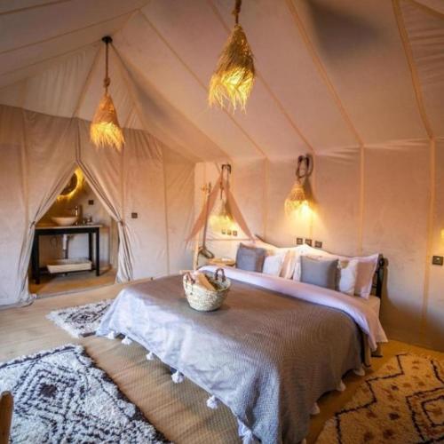 a bedroom with a bed in a tent at Nour Desert Luxury Camp in Merzouga