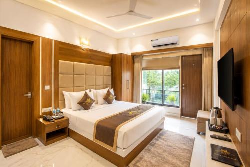 a bedroom with a large bed and a television at Taj View By Signature Stayz in Agra