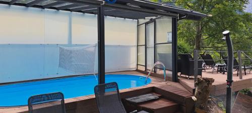 a house with a swimming pool and a deck with chairs at Apartments Smolej Kranjska Gora in Kranjska Gora