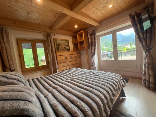 a bedroom with a large bed with a large window at Chalet l'Aiglon in Saint-Gervais-les-Bains