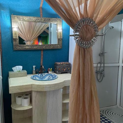 a bathroom with a sink and a mirror at Nour Desert Luxury Camp in Merzouga