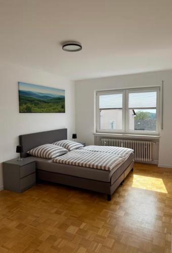 a bedroom with a large bed and two windows at Ferienwohnung Klaus in Clausen