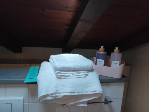 a pile of towels on a counter in a bathroom at Sogni in soffitta in Casalecchio di Reno