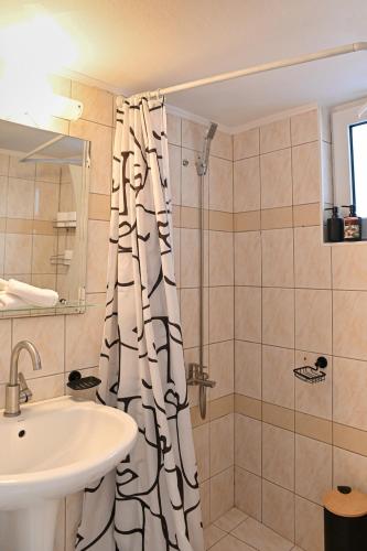 a bathroom with a shower curtain and a sink at CALLI HOUSE in Preveza