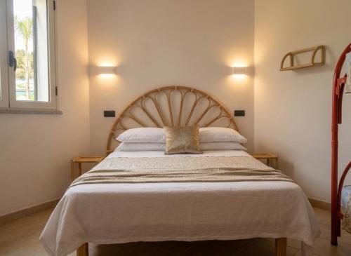 a bedroom with a large bed with a wooden headboard at House Betania in San Ferdinando