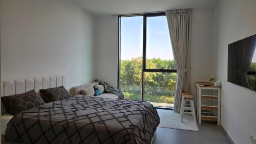 a bedroom with a bed and a large window at Kuro Homes in Sharjah