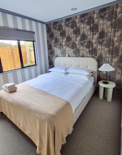 a bedroom with a large white bed and a window at Miro St Guest House in Mount Maunganui
