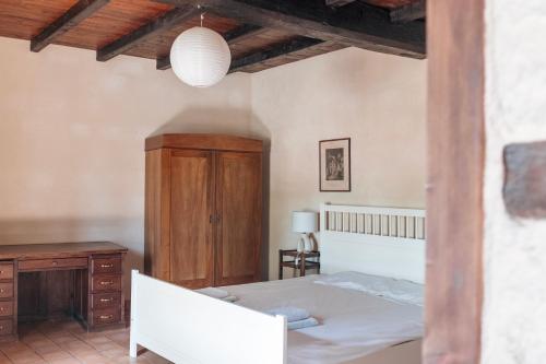 a bedroom with a white bed and a wooden cabinet at Saint Germain - Logis de Beaulieu in Poullignac