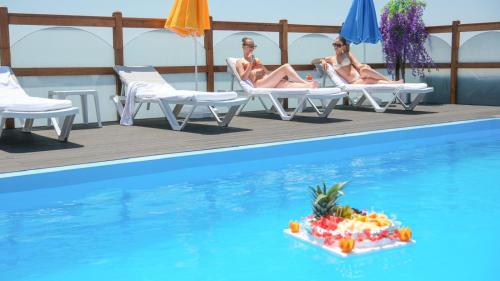 two women sitting in chairs next to a swimming pool at İstanbul Trend Hotel Old City in Istanbul