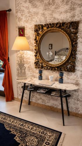 a mirror on a wall with a table and a lamp at Villa Incanto on the Sea in Syracuse