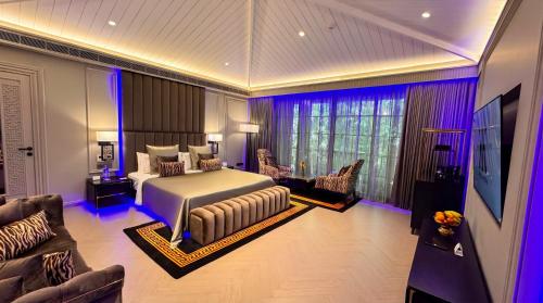 a bedroom with a bed and a couch and a tv at King's Mansion in Candolim