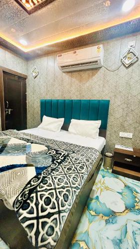 a bedroom with two beds with a blue headboard at Agrawal seva sadan in Mathura