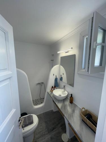 a white bathroom with a sink and a toilet at Saint Nectaire in Kardhianí