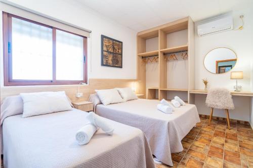 a room with two beds and a mirror at Casa Rural Casita de la Cantera in La Lantejuela