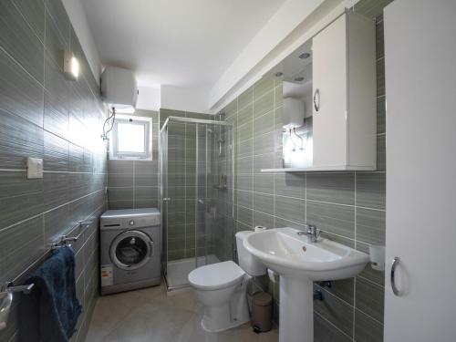 a bathroom with a toilet sink and a washing machine at Bayview Bliss Appartement just 50 steps from the beach in Santa Maria