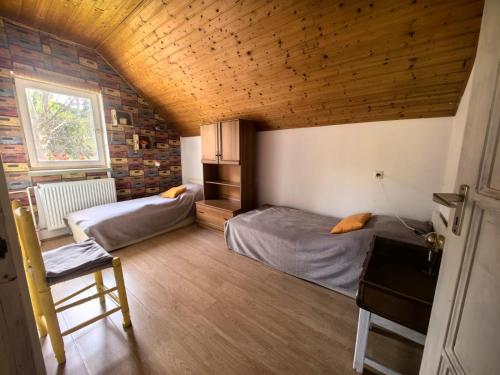 a bedroom with two beds in a room with a wooden ceiling at Mánfa-gyöngy Vendégház in Mánfa