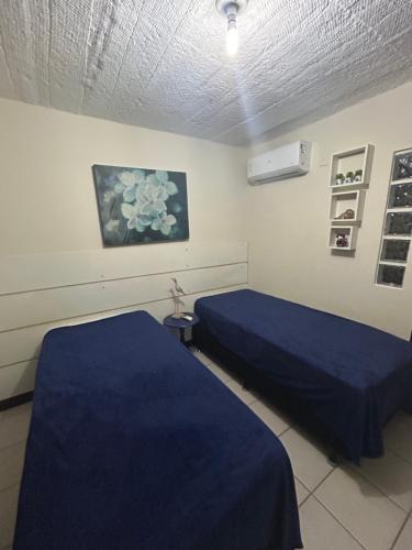 two beds in a hospital room with blue sheets at Vilarejo do farol in Praia do Forte