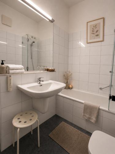 a white bathroom with a sink and a bath tub at Hotel Goldener Adler in Bautzen