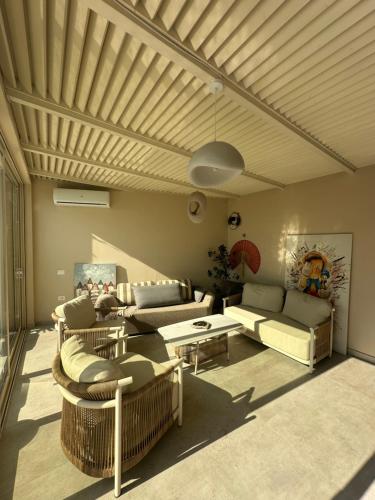 a living room with couches and a wooden ceiling at Villa RRE Green Coast in Palasë