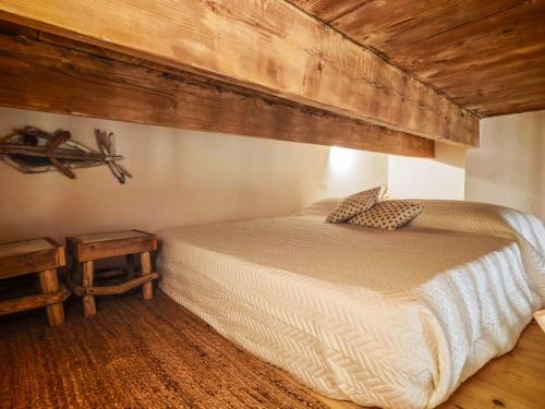 a bedroom with a bed and a wooden ceiling at Casetta Ismeralda in Carloforte