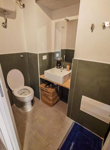 a bathroom with a toilet and a sink at Casetta Ismeralda in Carloforte