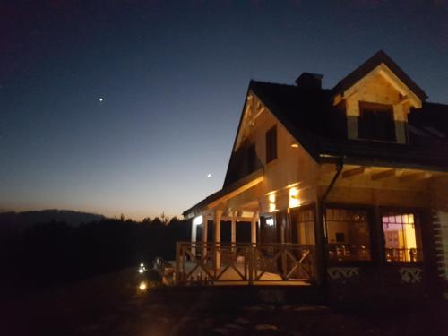 a house at night with the moon in the sky at Kompleks Małe Dolomity in Hucisko