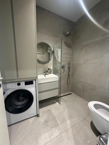 a bathroom with a washing machine and a sink at Villa RRE Green Coast in Palasë