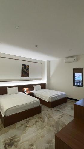 two beds in a large room with two beds sidx sidx sidx at Khách Sạn Phượng Vĩ in Cà Mau