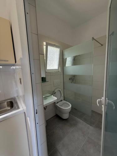a small bathroom with a toilet and a sink at Green House in Himare