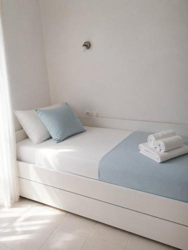 a bed in a white room with towels on it at Dinas house ofrinio in Ofrínion