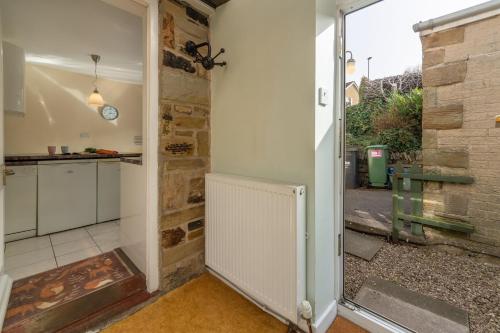 a kitchen with a door leading to a patio at Fox Cottage in Middleham
