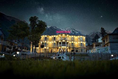 a large building with a sign on it at night at Falettis Grand Hotel Naran in Naran