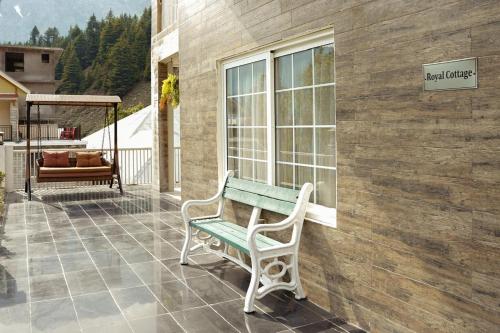 a bench sitting on the porch of a house at Falettis Grand Hotel Naran in Naran
