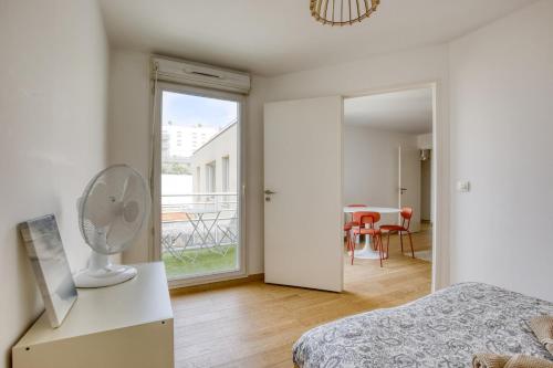 a bedroom with a bed and a table with a fan at Le Palacio in Saint-Denis
