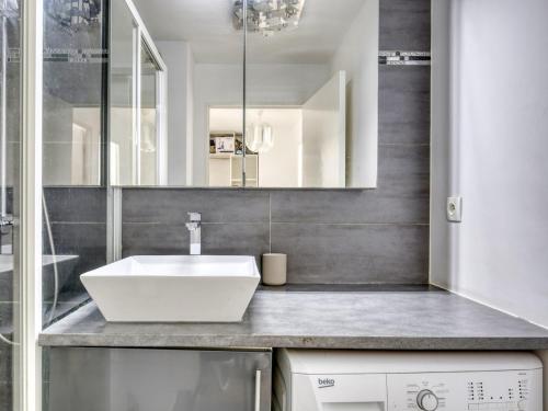 a bathroom with a white sink and a mirror at Le Palacio in Saint-Denis