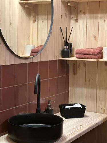 a bathroom with a black sink and a mirror at Kulturgården Bjerkem in Steinkjer