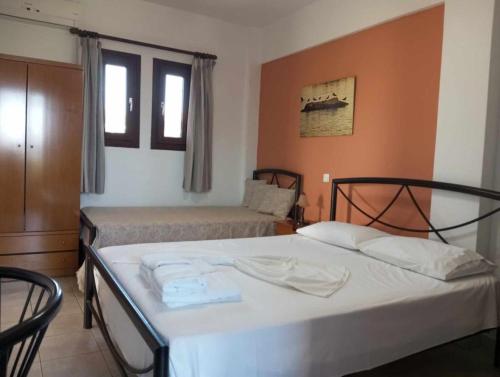 a bedroom with two beds and two windows at Studios Tripiti in Nea Roda
