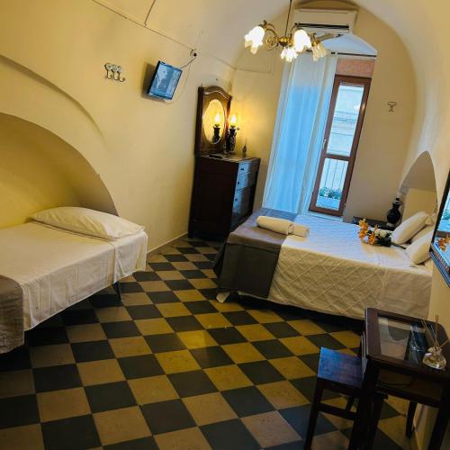 a room with two beds and a checkered floor at Santa Cesarea Sassi in Matera