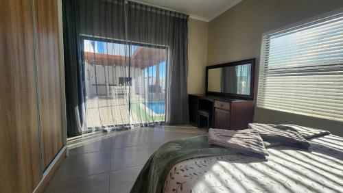 a bedroom with a bed and a large window at Ocean Whisper in Velddrif
