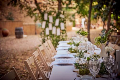 a long table with white plates and flowers on it at Hotel-Hostal Sport in Falset