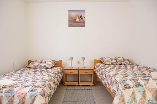two beds sitting next to each other in a bedroom at Apartman Sofija Palić in Palić