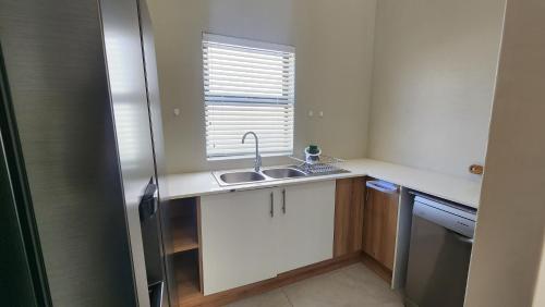 a small kitchen with a sink and a window at Ocean Whisper in Velddrif