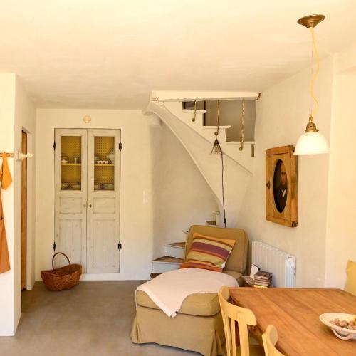 a living room with a staircase and a table at Au Canari gîte de charme in Saint-Sauveur-en-Puisaye