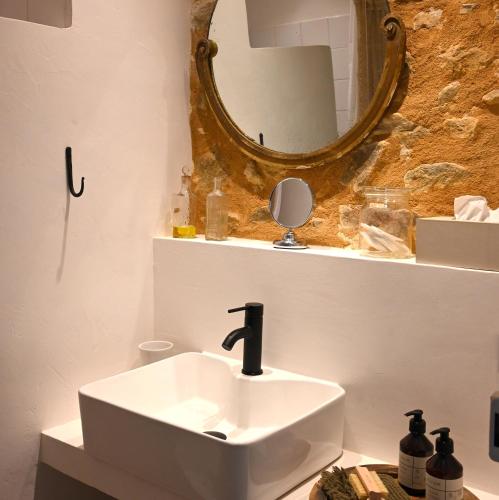 a bathroom with a white sink and a mirror at Au Canari gîte de charme in Saint-Sauveur-en-Puisaye