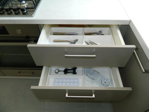 a kitchen with a drawer with knives and scissors at Kalithies apartment in Kalithies