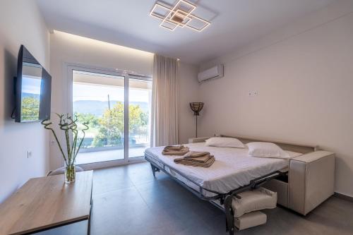 a bedroom with a bed and a large window at Enclave Luxury Apartments in Áyios Kírikos
