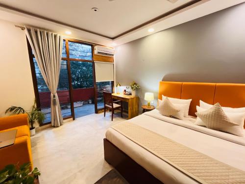 a bedroom with a bed and a desk and a window at Grove Residency Huaz Khas New Delhi - Couple Friendly in New Delhi