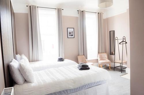 a bedroom with two white beds and a chair at Ship Inn in Wylam