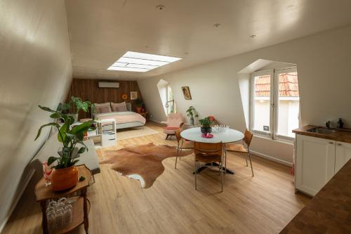 a living room with a table and a bed at Logement Welgelegen - Charming private stay with sauna near Nijmegen in Millingen aan de Rijn